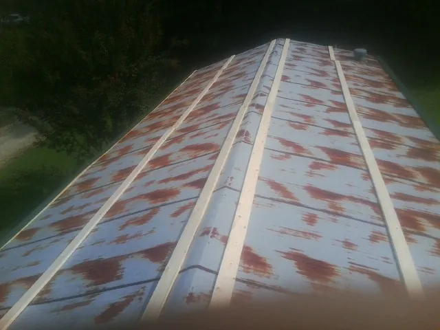 Rusted metal roof panels with new wood purlins before replacement — Storm Damage Roof Repair in Mc Intire by Roofing Brothers