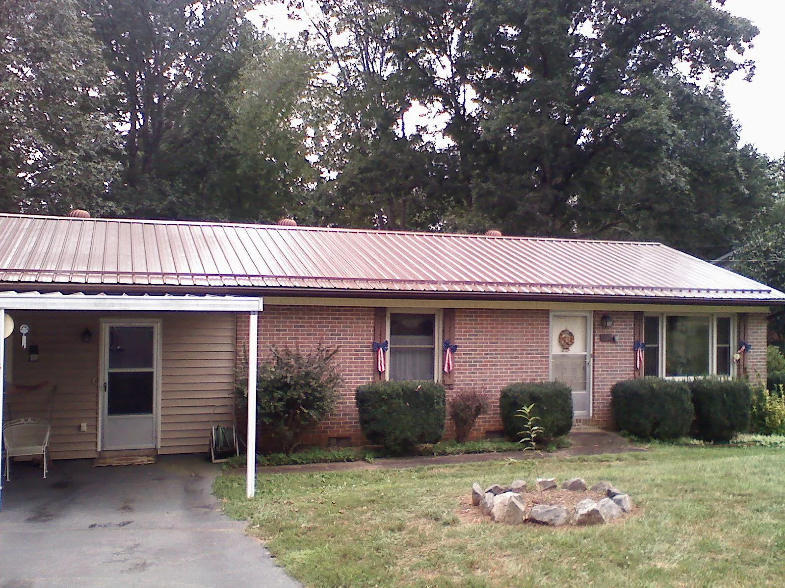 Bronze metal roof and carport on a brick ranch home — Roof Repair work by our crew in Mc Intire