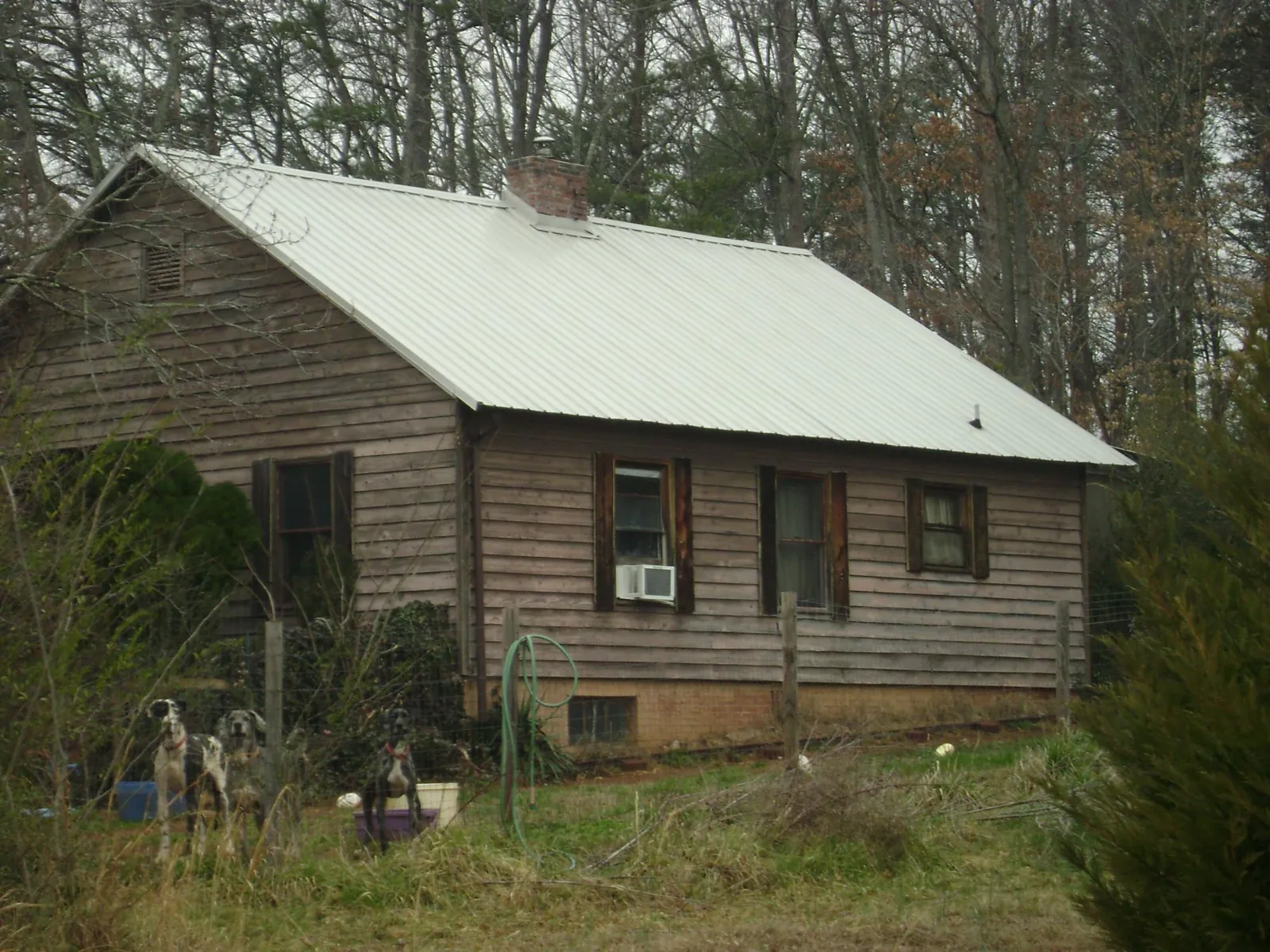 White metal roof on an old wood sided farmhouse, from a Metal Roof Installation job in Mc Intire